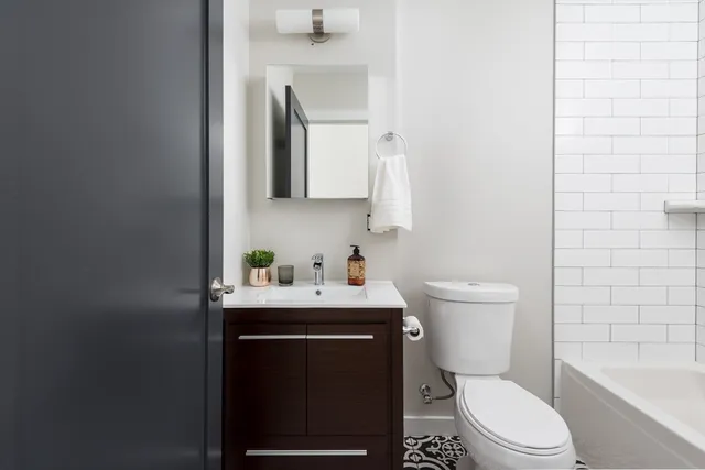a bathroom with a toilet a sink a mirror and bathtub