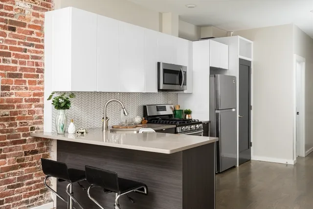 a kitchen with stainless steel appliances a sink a refrigerator a stove a microwave and cabinets