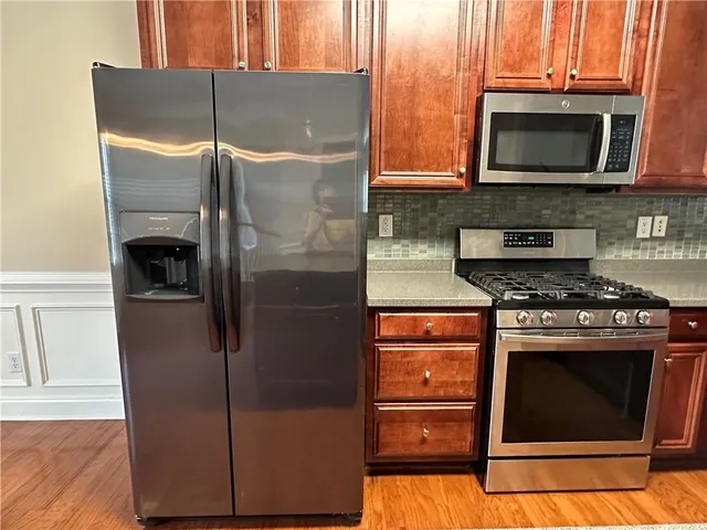 a kitchen with granite countertop a refrigerator stove and microwave