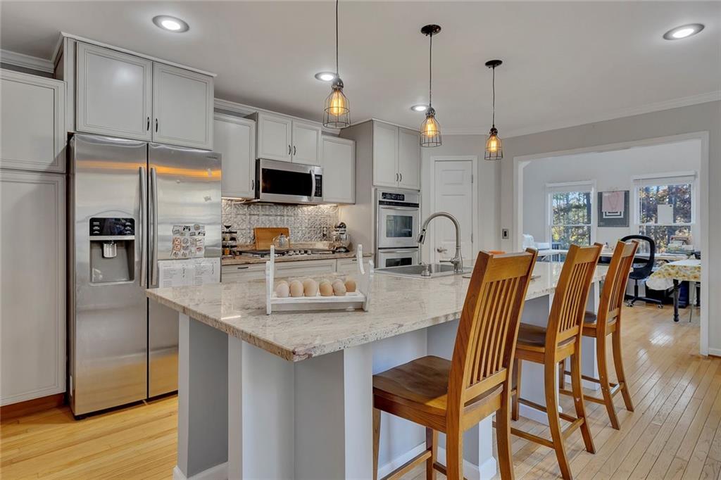 1620 Palm Street Canton, GA 30115 - Photo 13 of 72 a kitchen with stainless steel appliances granite countertop a kitchen island a stove a refrigerator a oven a sink with a dining table and chairs