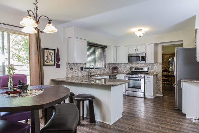 710 Heather Lane Bartlett, IL 60103 - Photo 5 of 26 a kitchen with stainless steel appliances a dining table chairs stove refrigerator and microwave