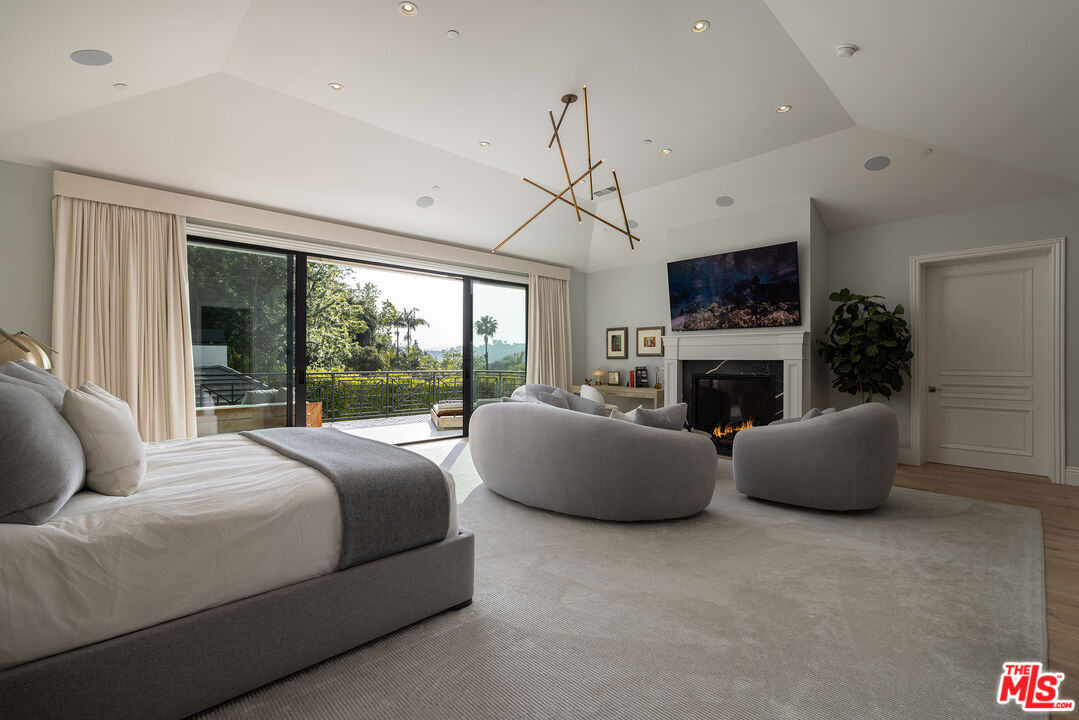 9520 Hidden Valley Road Beverly Hills, CA 90210 - Photo 13 of 29 a bedroom with bed a couch and a fireplace