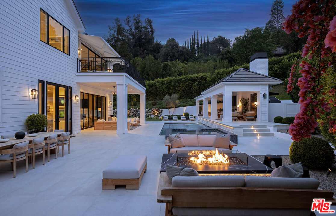 9520 Hidden Valley Road Beverly Hills, CA 90210 - Photo 28 of 29 a view of a patio with couches table and chairs with wooden fence and plants
