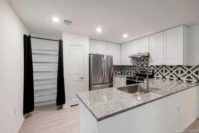 a kitchen with a refrigerator and a sink