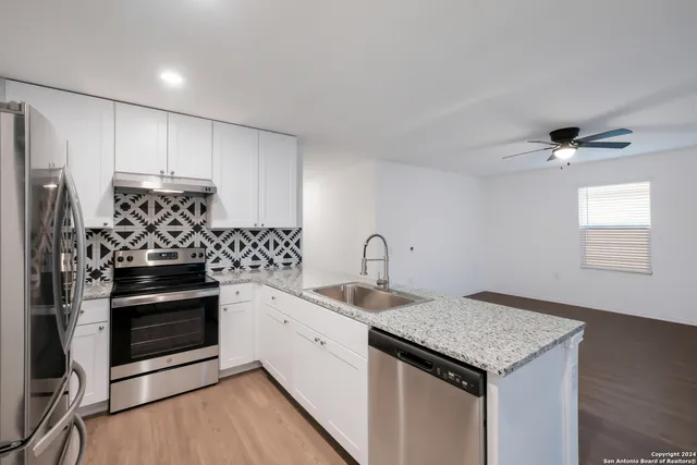 a kitchen with stainless steel appliances granite countertop a sink stove and refrigerator