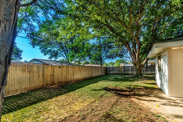 a view of a backyard with wooden fence