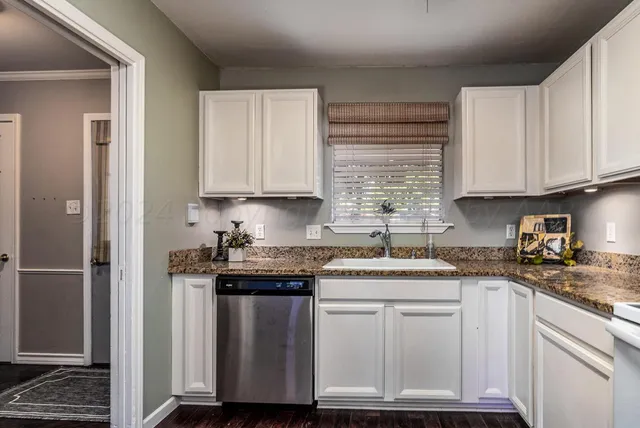 a kitchen with stainless steel appliances granite countertop a sink stove and cabinets