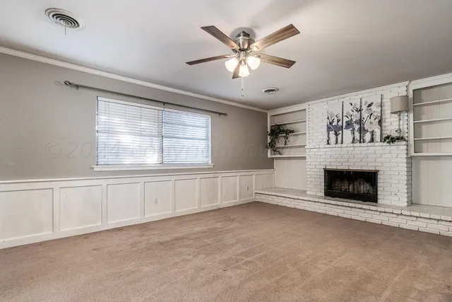 a view of an empty room with a fireplace and a window
