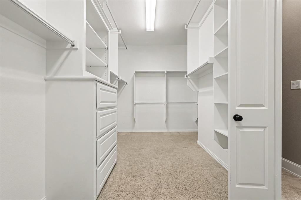 408 Blue Ridge Court Allen, TX 75013 - Photo 21 of 31 Walk-in closet featuring white built-in shelving, hanging rods, and a four-drawer dresser