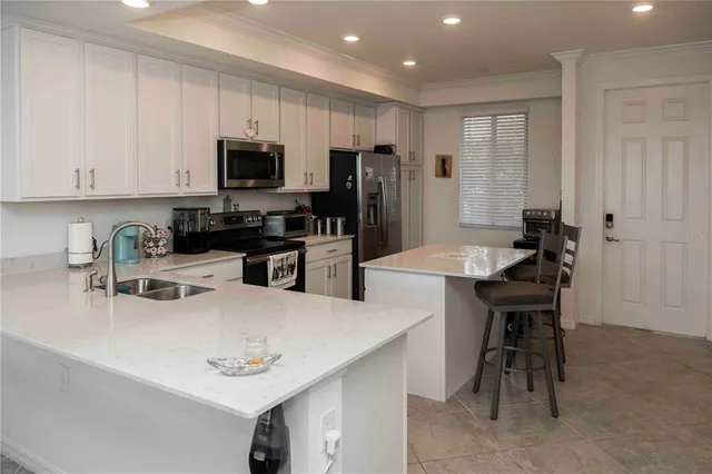 a kitchen with stainless steel appliances kitchen island granite countertop a sink dishwasher stove and cabinets