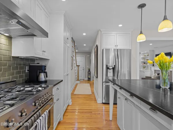 a kitchen with stainless steel appliances granite countertop a stove a refrigerator and a wooden cabinets