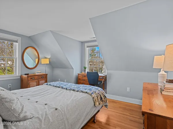 a bedroom with a bed and a mirror on dresser