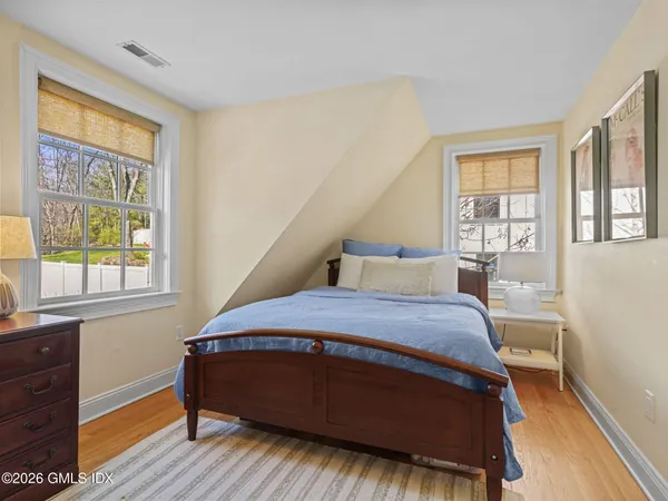 a bedroom with a bed and windows