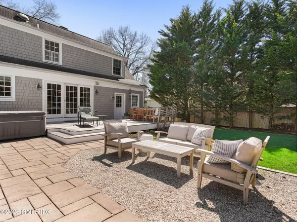 a view of a patio with couches and a table and chairs with wooden fence and plants
