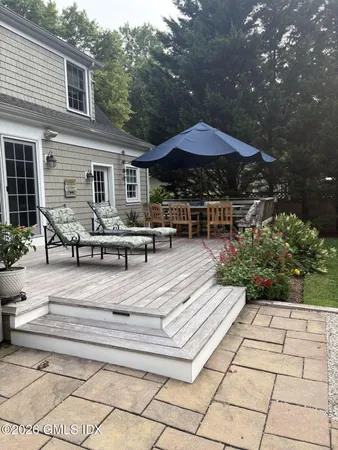 a view of patio with table and chairs under an umbrella with a barbeque