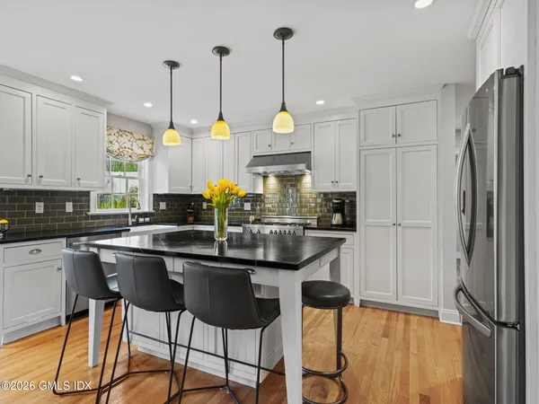 a kitchen with stainless steel appliances granite countertop a refrigerator a sink and a stove