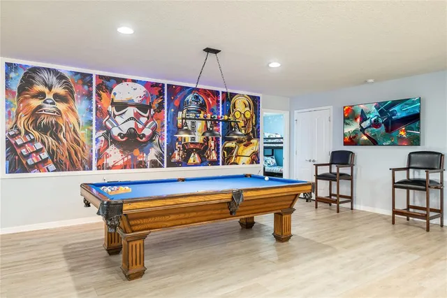 a media room with lots of chairs and wooden floor