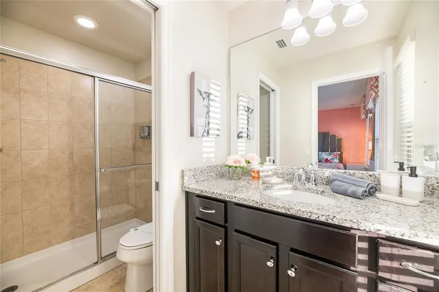 a bathroom with a granite countertop double vanity and a mirror