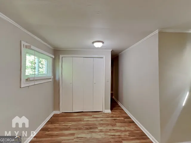 a view of an empty room with wooden floor