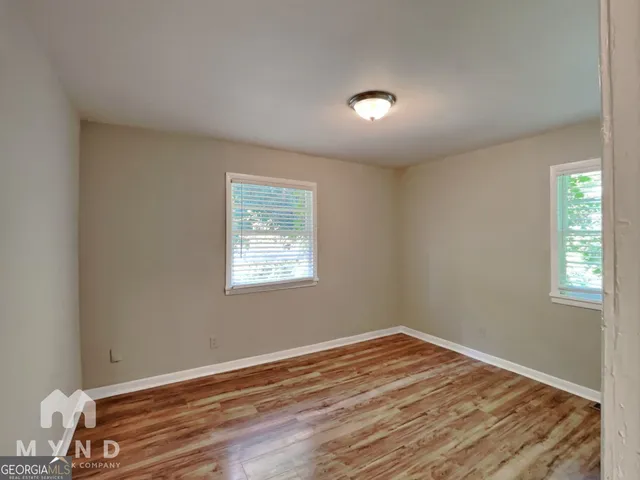 a view of empty room with wooden floor