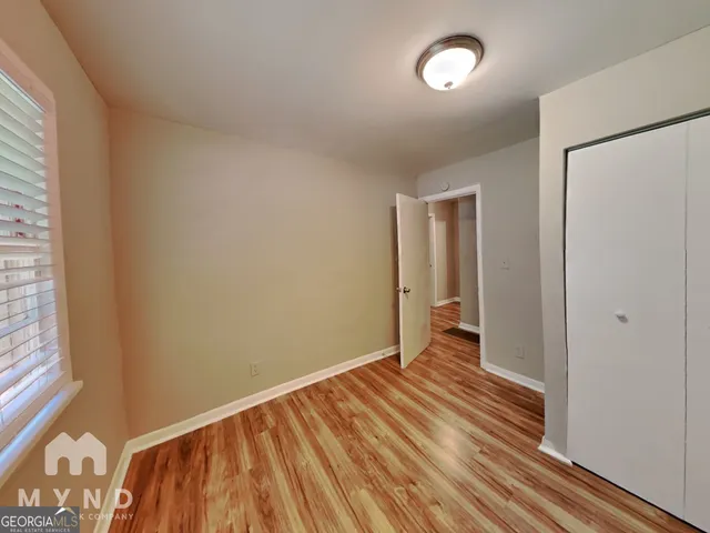 a view of a room with wooden floor and a window