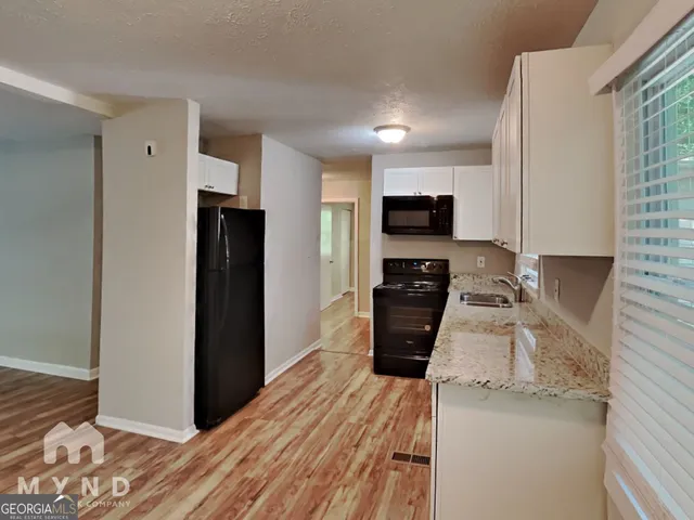 a kitchen with granite countertop a refrigerator stove and oven