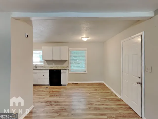 a view of kitchen and hallway with wooden floor