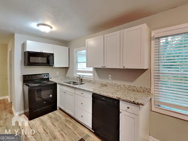 a kitchen with granite countertop a sink and steel appliances