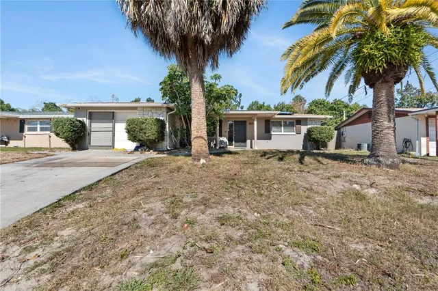 a front view of house with yard and trees around