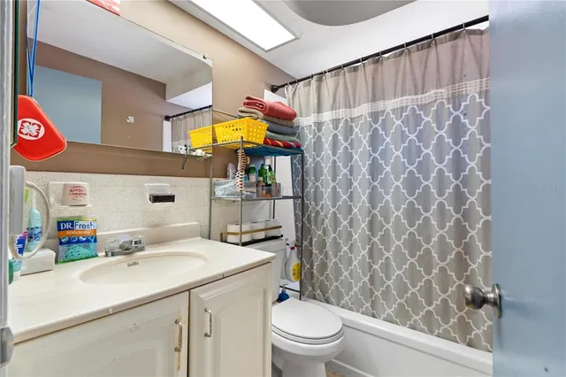 a bathroom with a sink a toilet and shower curtain