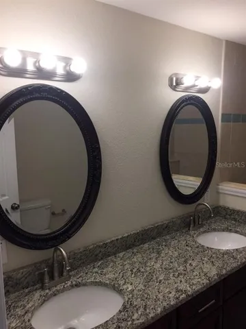 a bathroom with a granite countertop sink and mirror