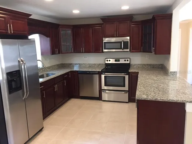 a kitchen with stainless steel appliances granite countertop a stove a microwave a sink and a refrigerator