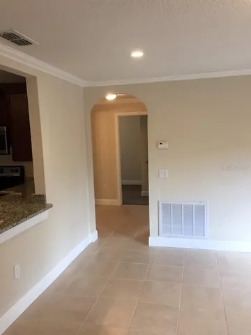 a view of a hallway to room with wooden floor