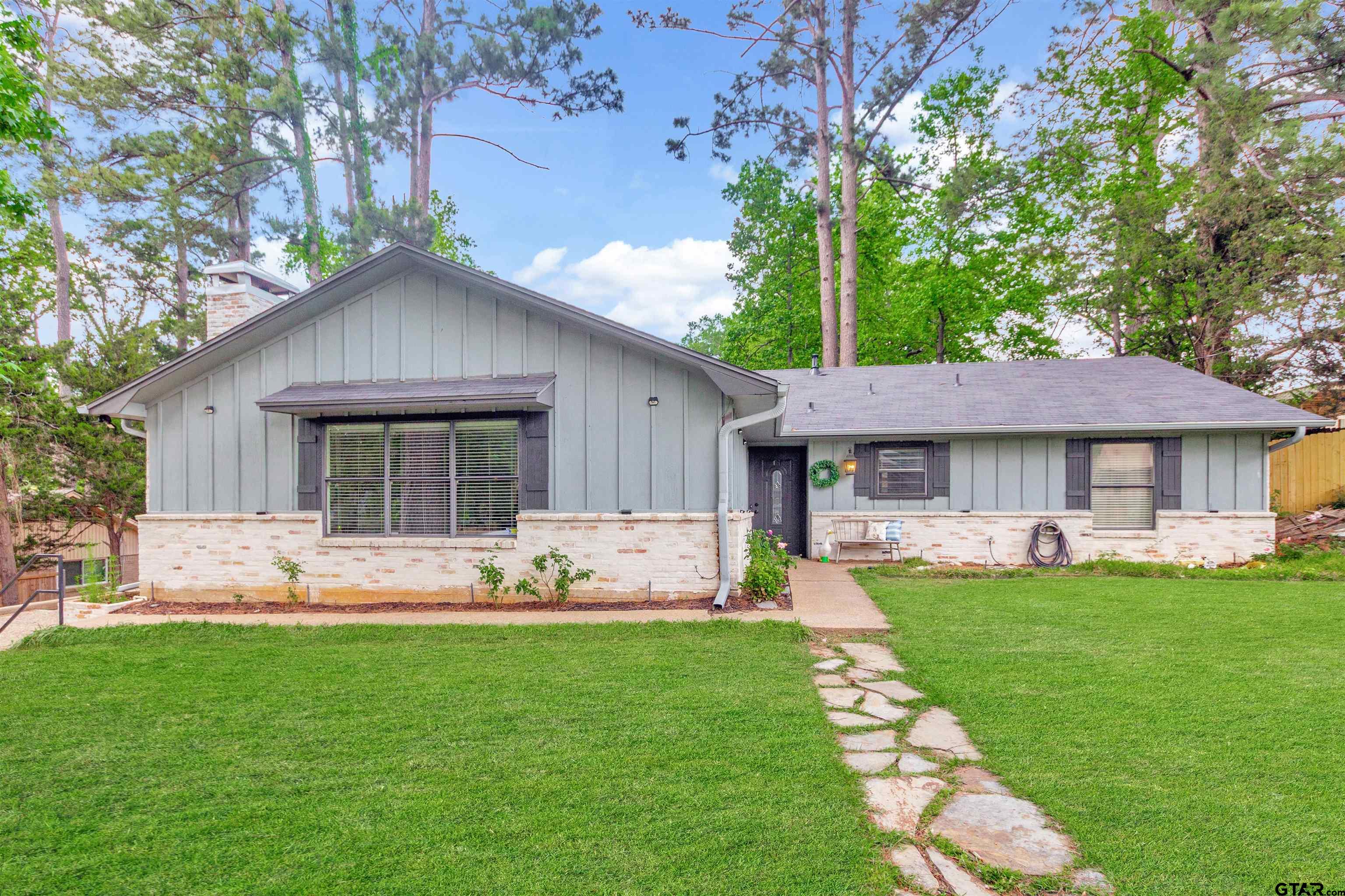1908 Waunell Drive Tyler, TX 75701 - Photo 1 of 39 a front view of a house with a garden and patio