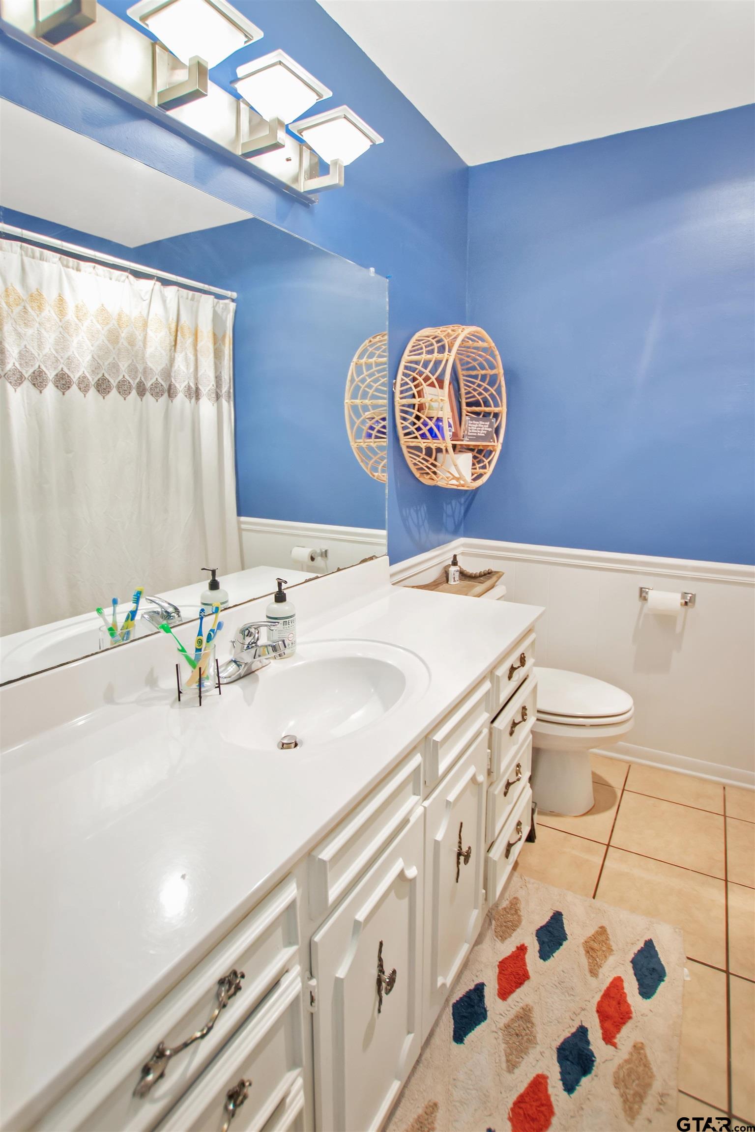 1908 Waunell Drive Tyler, TX 75701 - Photo 22 of 39 a bathroom with a sink a toilet and a shower curtain