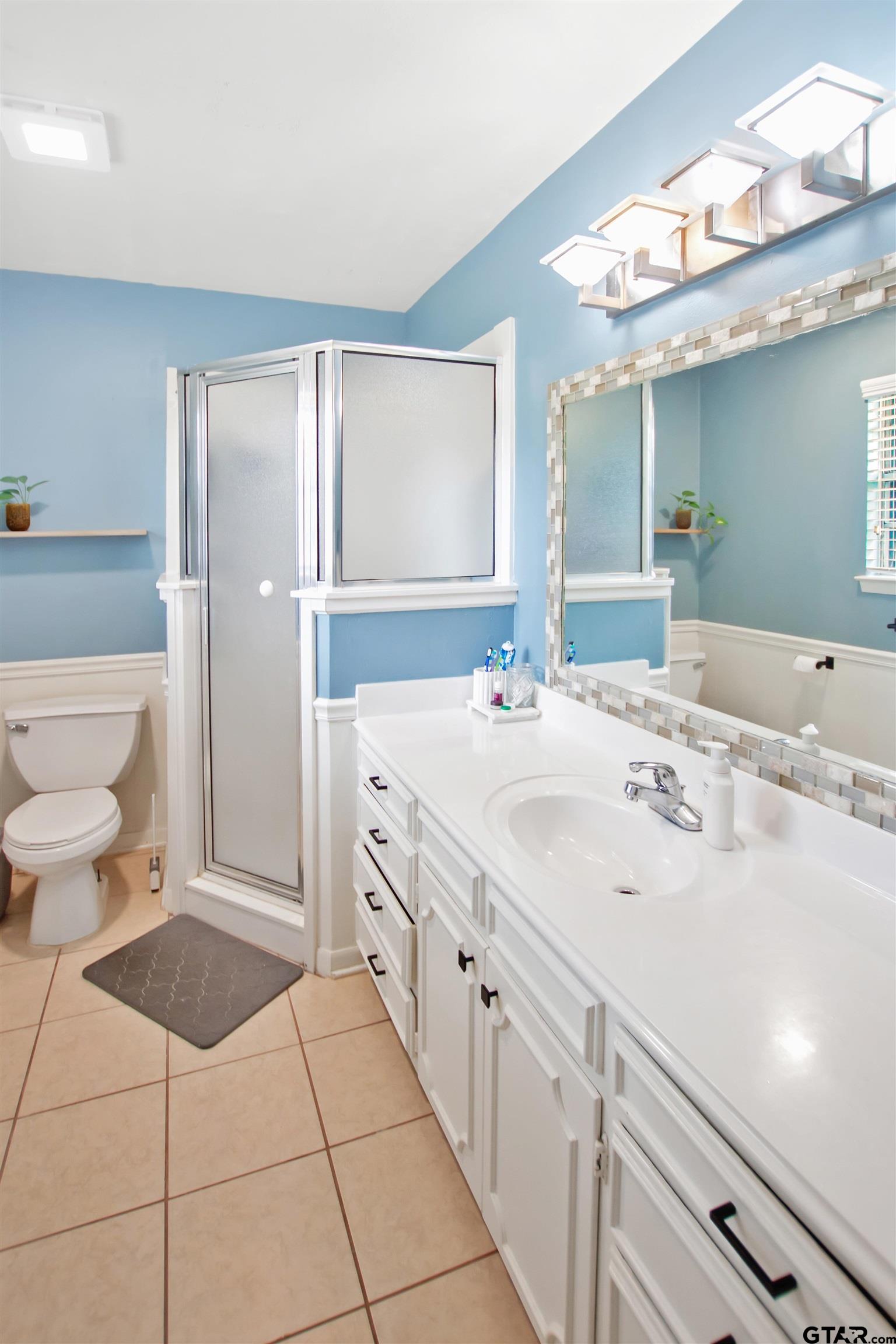 1908 Waunell Drive Tyler, TX 75701 - Photo 28 of 39 a spacious bathroom with a sink a toilet and mirror