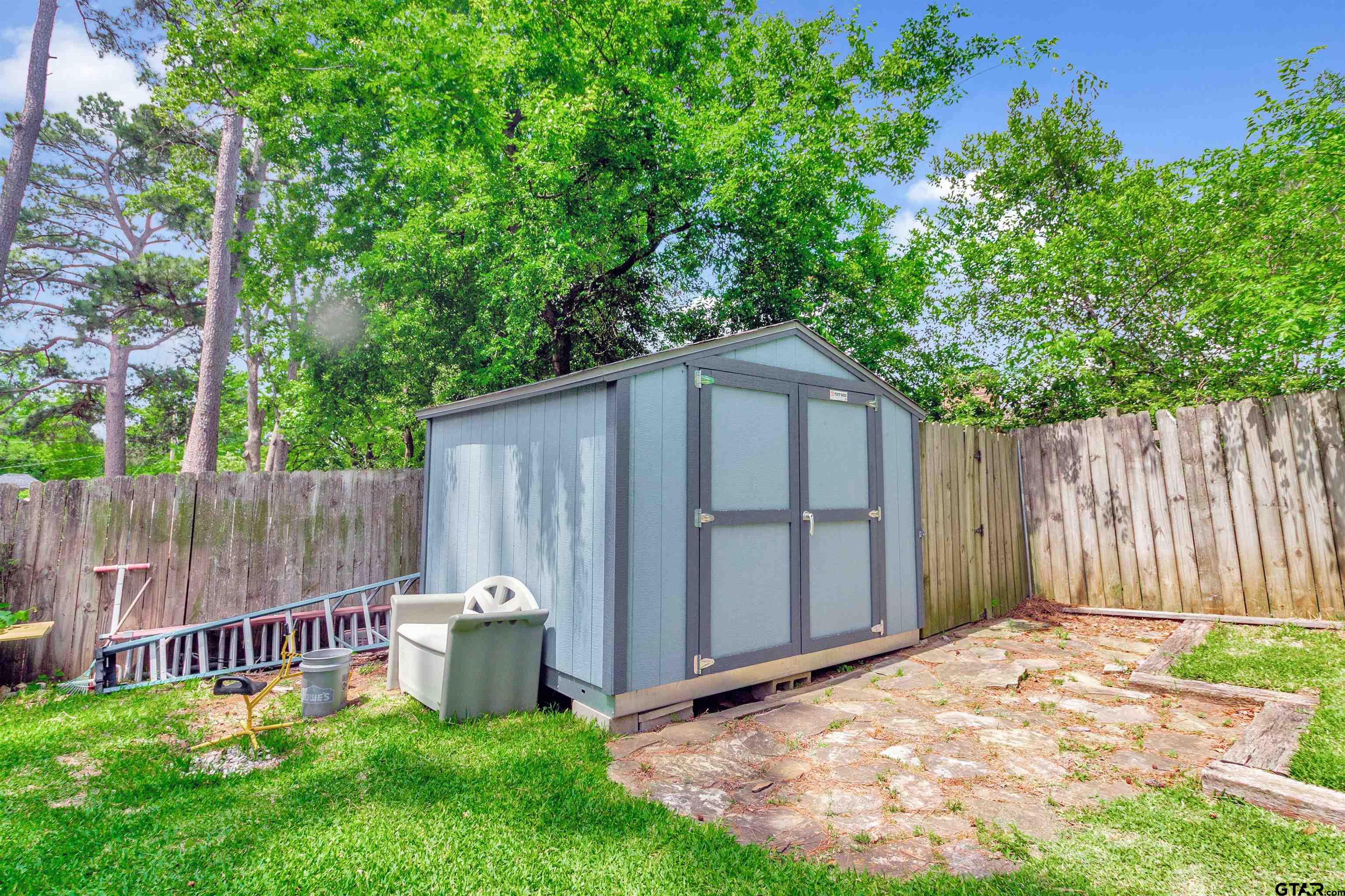 1908 Waunell Drive Tyler, TX 75701 - Photo 39 of 39 a view of a backyard with a small cabin and wooden fence