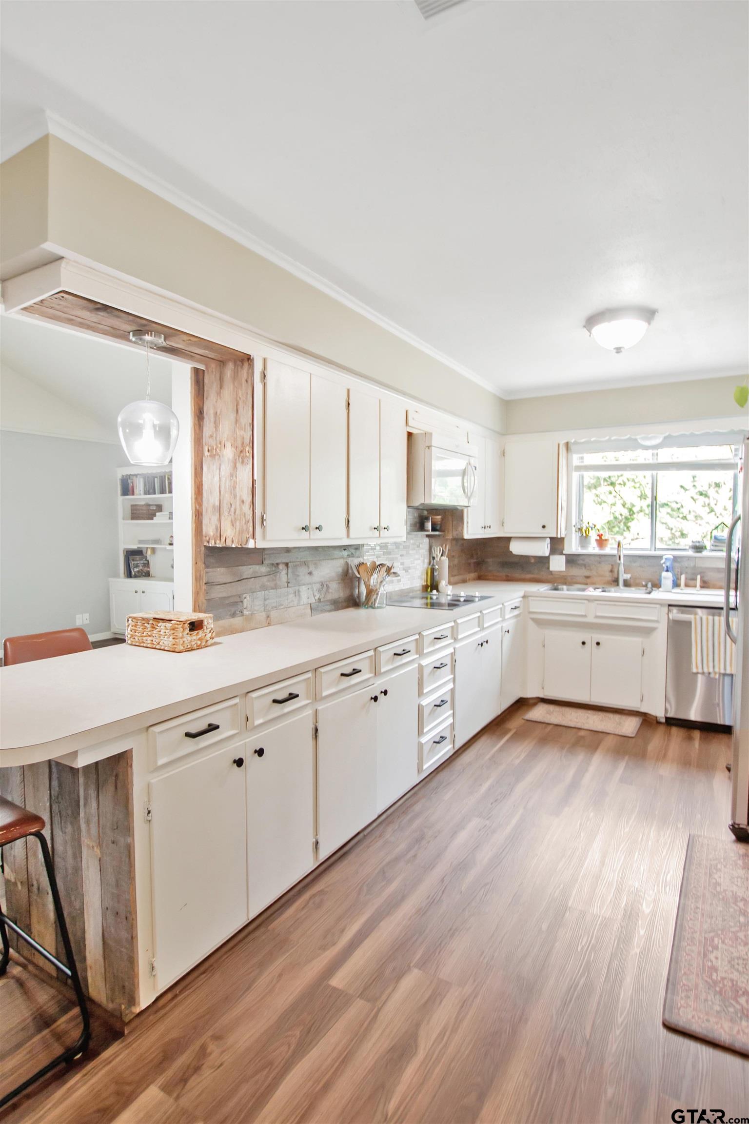 1908 Waunell Drive Tyler, TX 75701 - Photo 6 of 39 a large kitchen with a lot of white cabinets and wooden floor