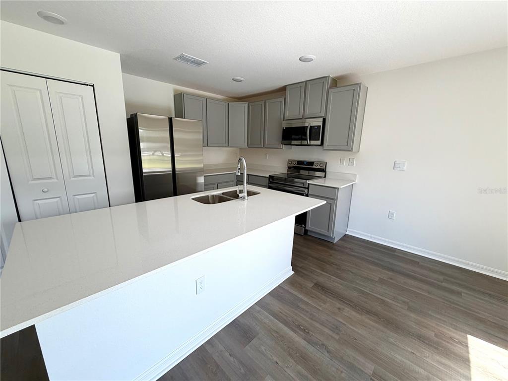 6000 East Oneida Street Inverness, FL 34452 - Photo 9 of 32 a kitchen with stainless steel appliances a sink a stove a microwave and cabinets
