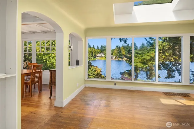 a view of a room with a large window and wooden floor