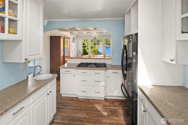 a kitchen with granite countertop white cabinets and white appliances