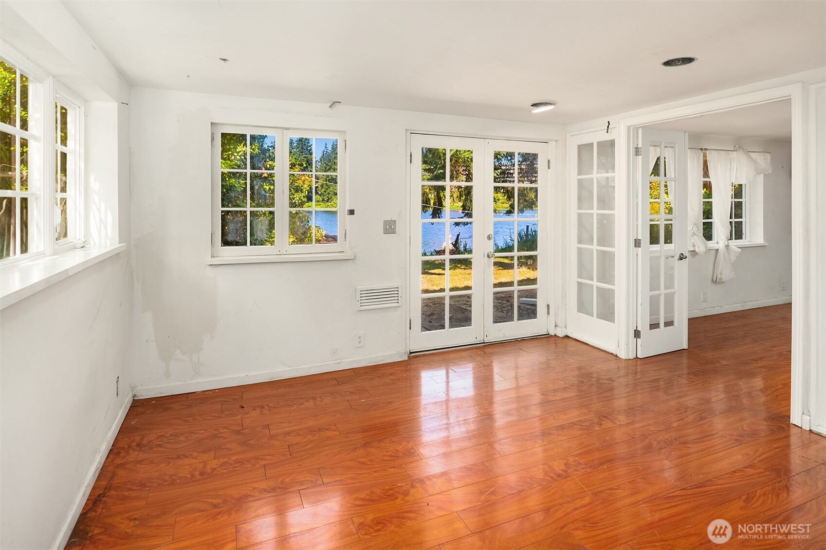 13302 Bitter Place North Seattle, WA 98133 - Photo 10 of 16 an empty room with wooden floor and windows