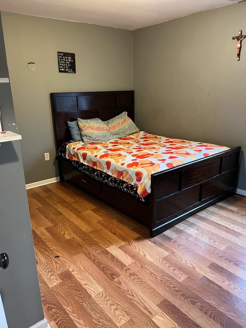 7 Ridge Circle Streamwood, IL 60107 - Photo 5 of 8 a bedroom with a bed and wooden floor