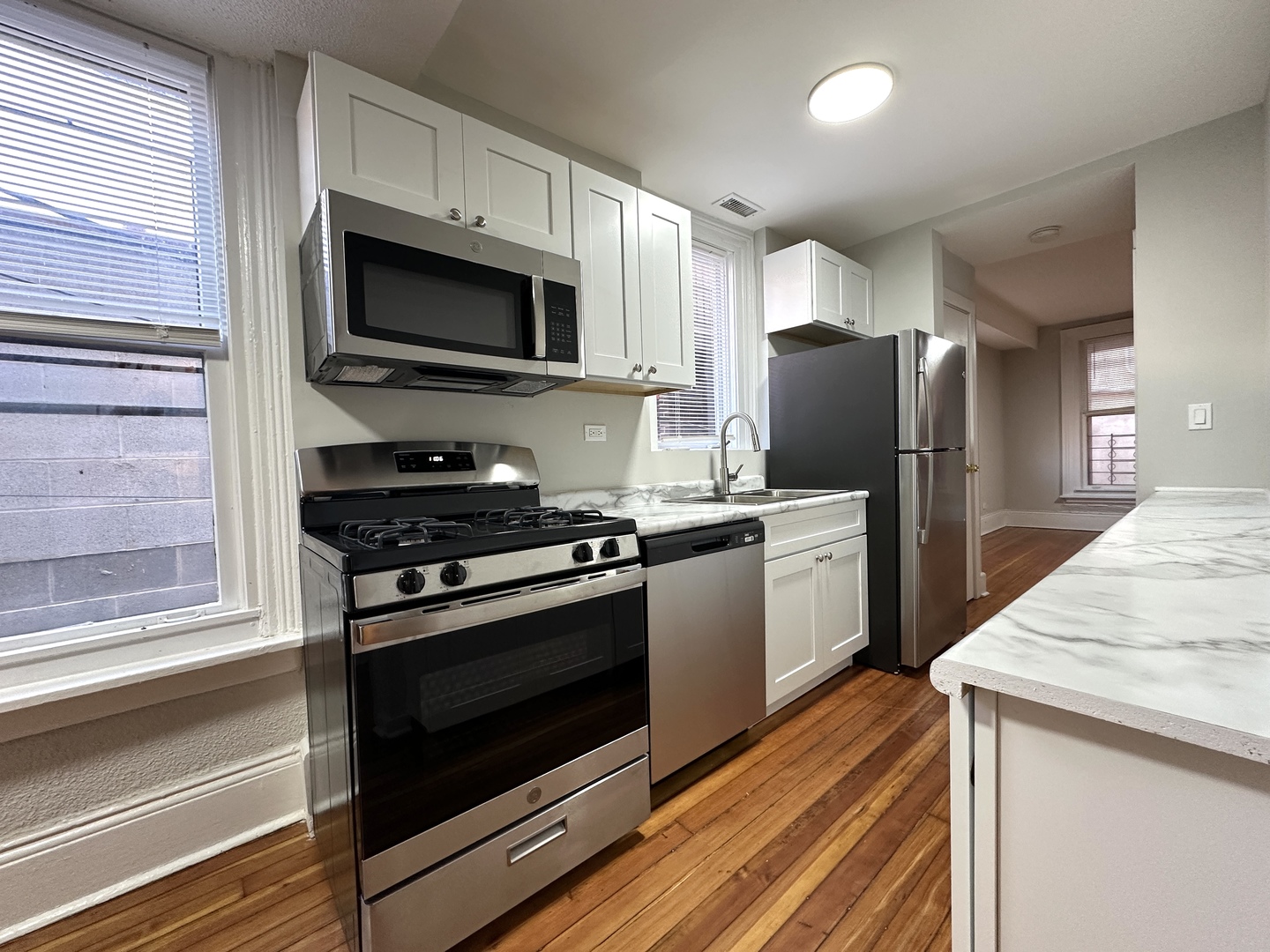 2052 North Dayton Street, Unit 2R Chicago, IL 60614 - Photo 5 of 11 a kitchen with stainless steel appliances and white cabinets