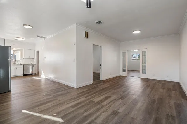 a view of empty room with wooden floor