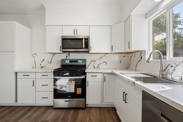 a kitchen with appliances a sink and a stove
