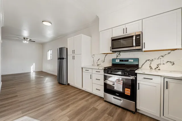 a kitchen with stainless steel appliances a stove microwave and a refrigerator