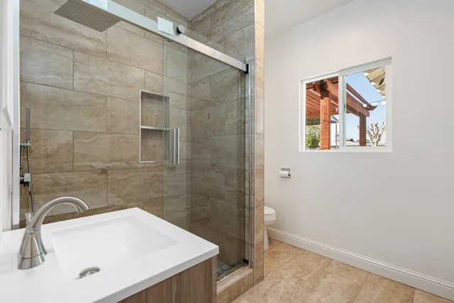 a bathroom with a sink a toilet and shower