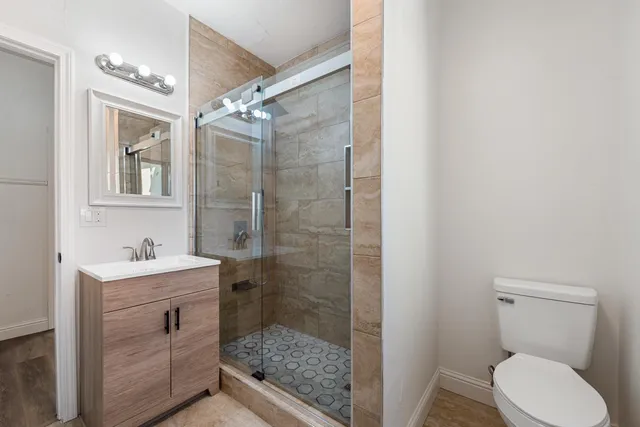 a bathroom with a sink a toilet and shower