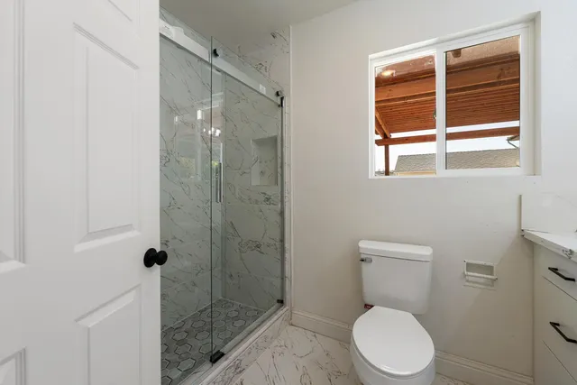 a bathroom with a toilet a sink and shower